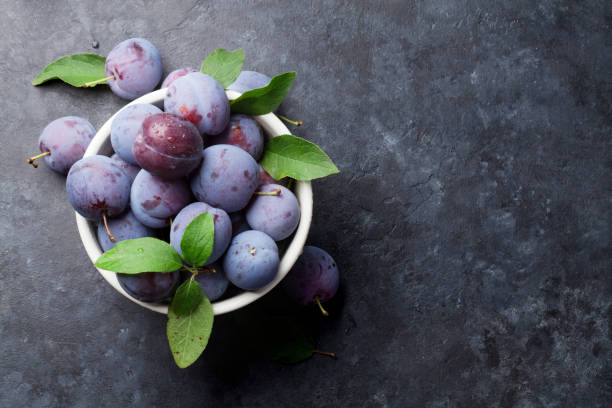 istock Garden plums in bowl on stone table 819568782