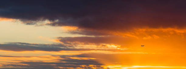 istock Colorful dramatic sky with silhouette of a plane 819578952