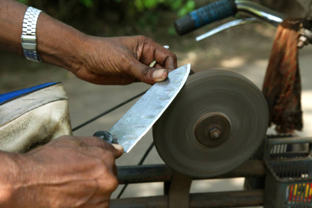 sharpening the knife with whetstone - old fashioned domestic kitchen old close up imagens e fotografias de stock