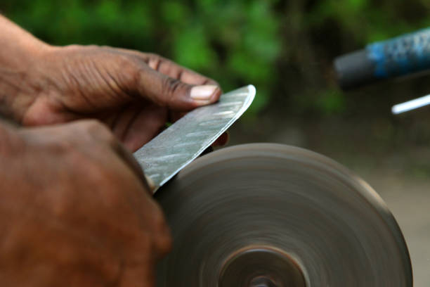 sharpening the knife with whetstone - old fashioned domestic kitchen old close up imagens e fotografias de stock