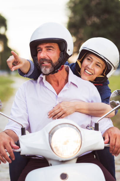 istock Happy Mature Couple Driving Scooter 819584634