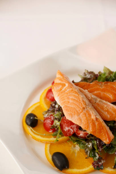 istock Salmon with vegetables arranged on a plate, Traditional dish in elegant setting, Selective focus with soft light 819585152