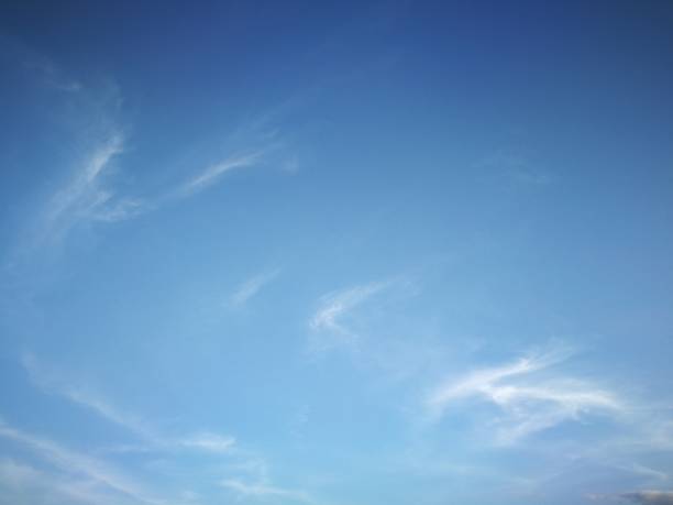 Clear blue sky with soft white clouds stock photo