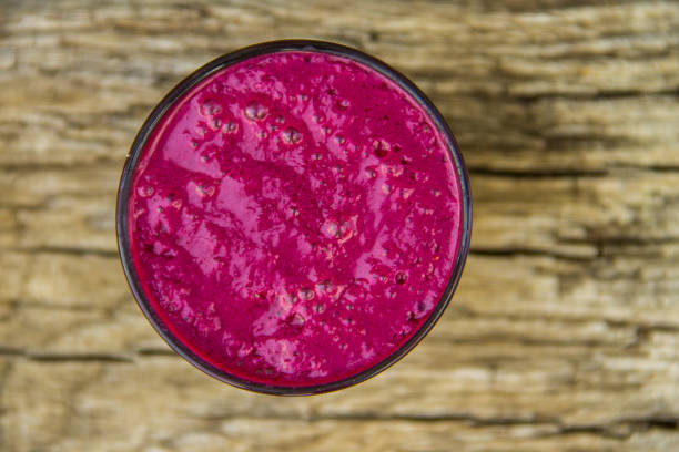 istock Glass of berry smoothie on rustic wooden table 819588192
