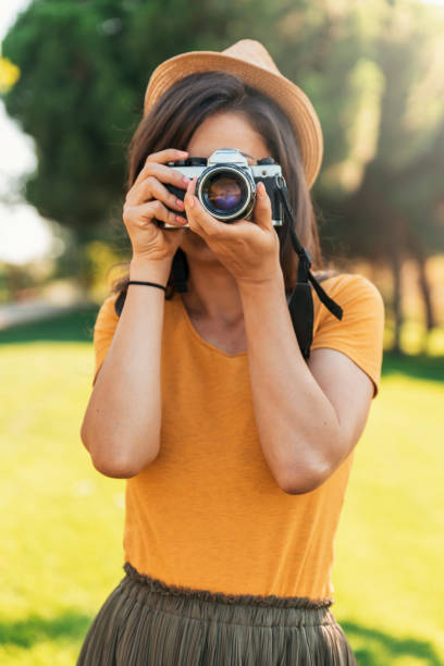 istock Young woman using a camera to take photo. 819604412