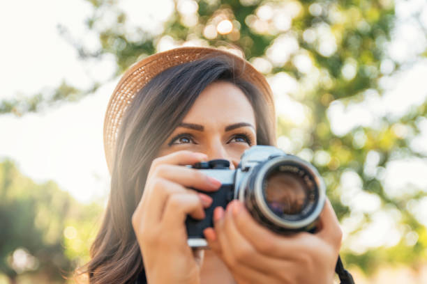 istock Young woman using a camera to take photo. 819604428