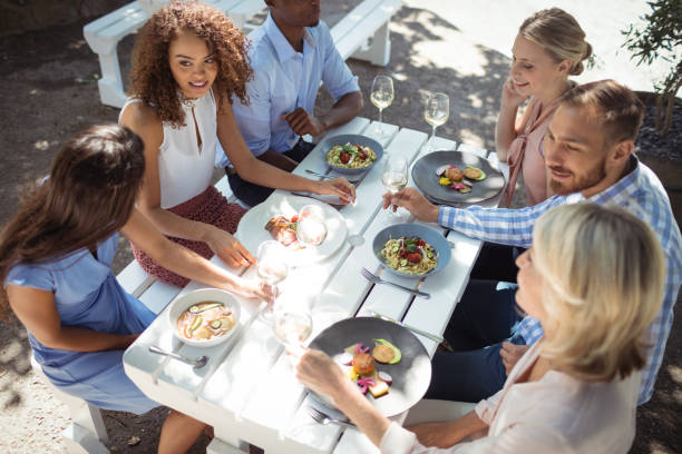 istock Happy friends interacting with each other while having meal 819611764