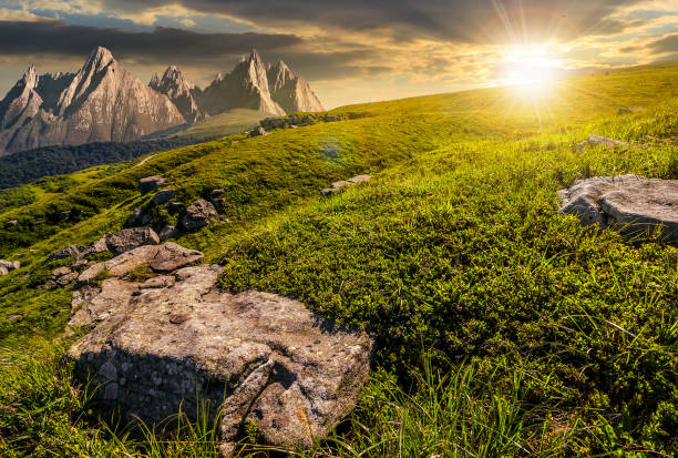 istock meadow with huge stones on top of mountain range at sunset 819612568