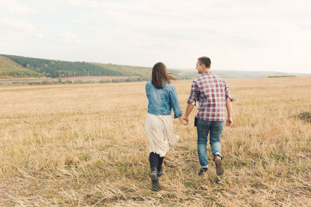 Midsection of a man and woman walking together. Close-up shot.