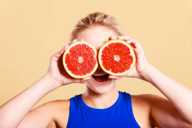 istock Woman holding grapefruit citrus fruit in hands 819615556