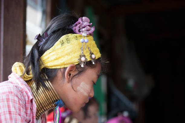 Unidentified Padaung senior woman wearing the traditional metal rings around her neck, INLE LAKE,MYANMAR-FEBRUARY 15,2016 : Unidentified Padaung senior woman wearing the traditional metal rings around her neck, working at a weaving in village of Inle lake, Shan state, Myanmar. kayan neck rings stock pictures, royalty-free photos & images