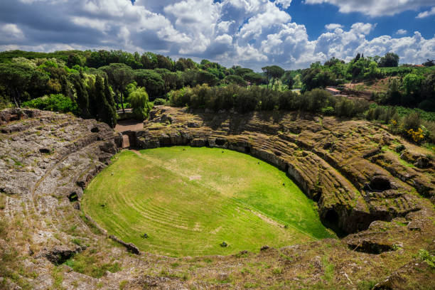 Ancient roman tuff stone amphitheater in the town of Sutri with clouds, near Rome