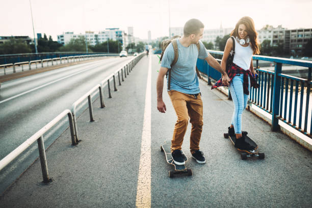 istock Young attractive couple riding skateboards and having fun 819636508