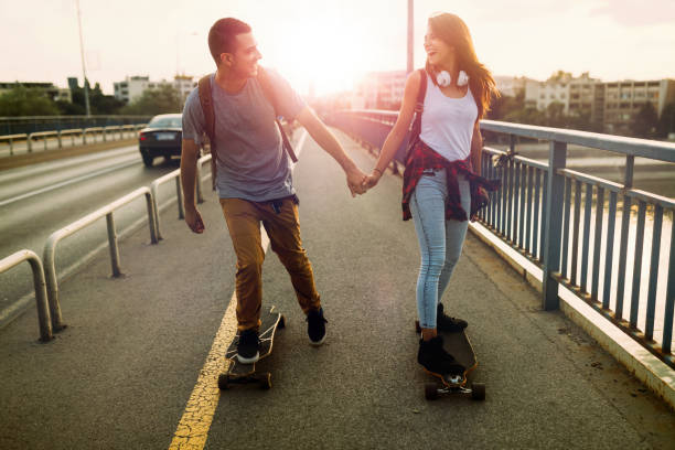 istock Young attractive couple riding skateboards and having fun 819636546