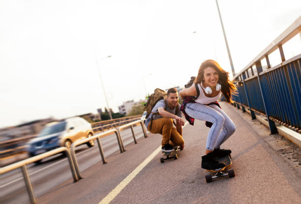 istock Young attractive couple riding skateboards and having fun 819636934