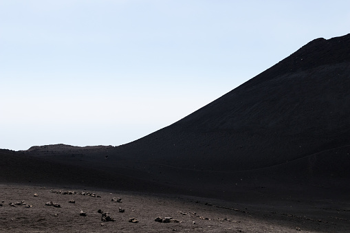 Lava hill and volcanic ash on the Mount Etna. Martian and unreal landscape with rocks, sand and black pebbles
