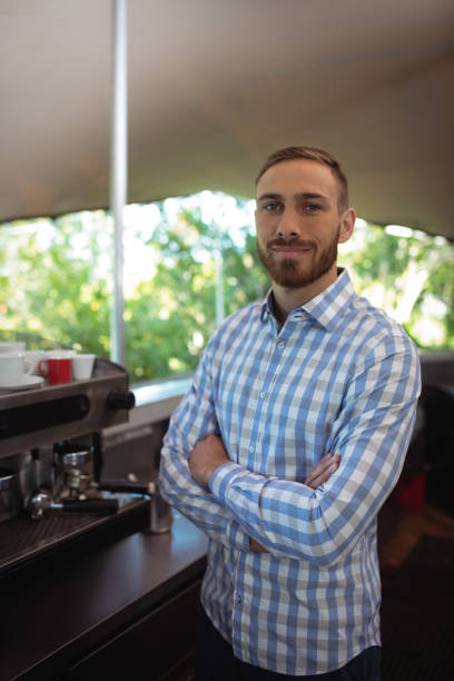 istock Smiling manager standing with arms crossed in restaurant 819640522