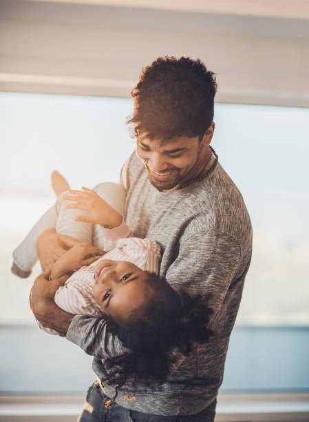 istock Happy African American father having fun while playing with his small daughter. 819640598