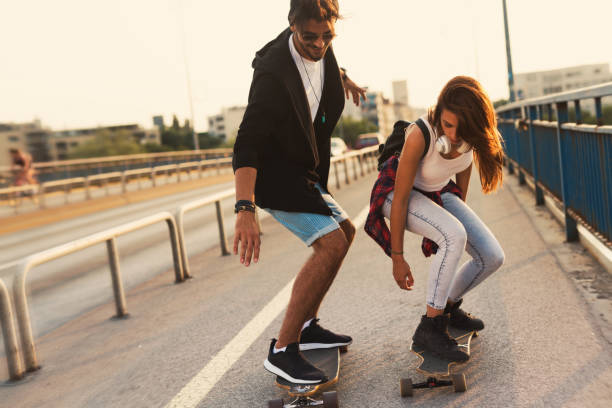 istock Young attractive couple riding skateboards and having fun 819643546