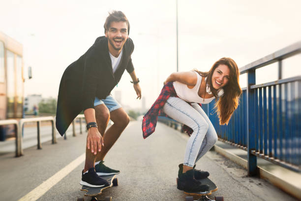 istock Young attractive couple riding skateboards and having fun 819643878