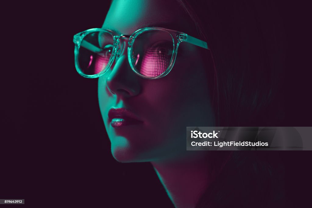 headshot of stylish young woman in sunglasses looking away Black Background Stock Photo