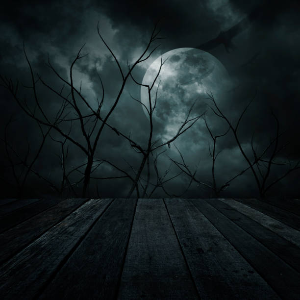 istock Old wooden table over dead tree, moon, birds and spooky cloudy sky, Halloween background 819643944