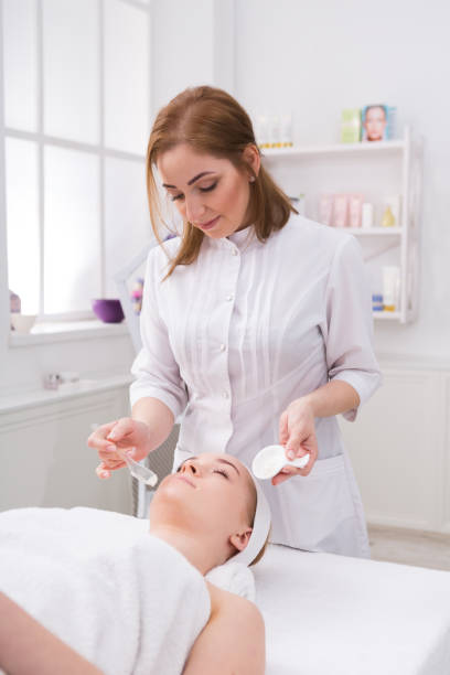 istock Woman gets face mask by beautician at spa 819643974