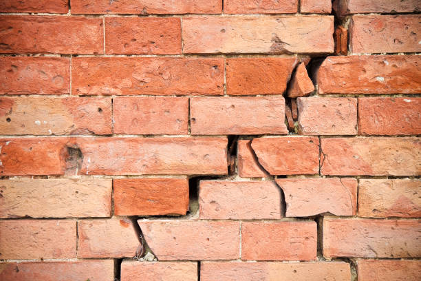 deep crack in old brick wall - concept image - crevice imagens e fotografias de stock