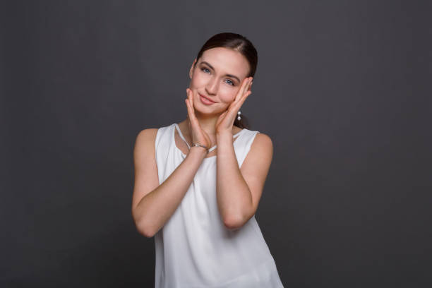 istock Young woman touching her face 819650990