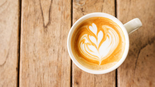 istock Hot latte coffee on a wooden table. 819651288