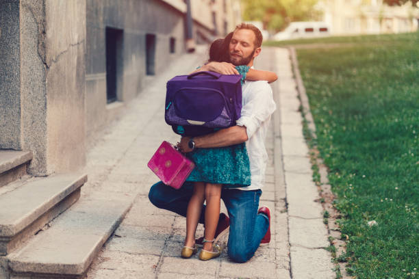 Little girl hugging her father before going to school Cute girl embracing her father for goodbye and leaving to school packed lunch photos stock pictures, royalty-free photos & images