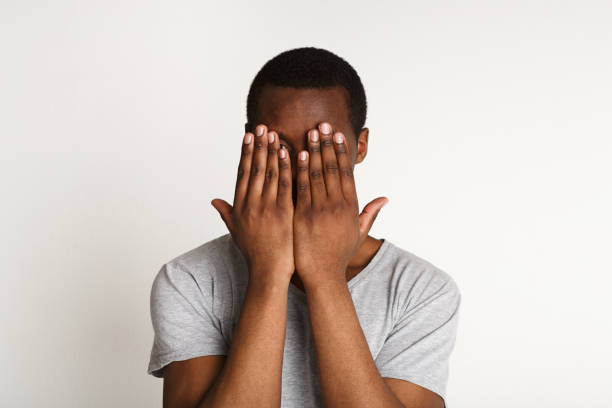 istock Scared black man covering eyes with hands, see no evil 819659404