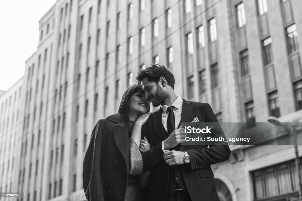 Young and elegant people Two people, man and woman, heterosexual couple, standing on the street, black and white. Couple - Relationship Stock Photo