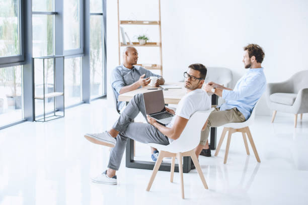 istock multicultural group of businessmen sitting at workplace in light modern office 819662320