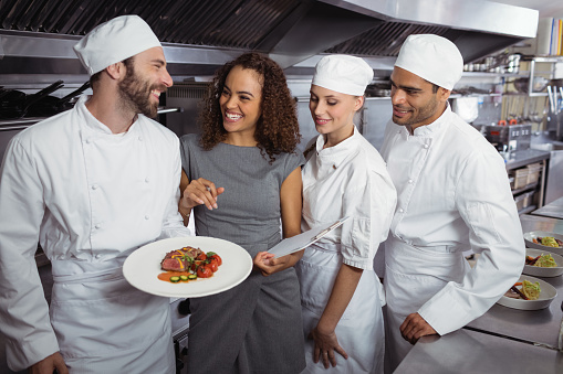 Restaurant manager interacting with his kitchen staff in commercial kitchen