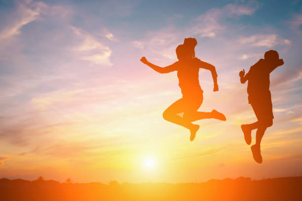 istock silhouette of a happy people and sunset 819665560