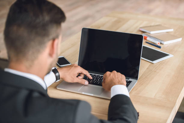 istock back view of businessman working on laptop at workplace in office 819665758