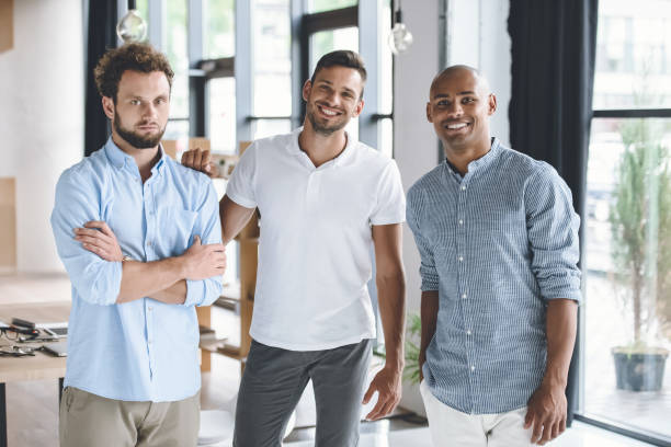 istock multiethnic young businessmen looking at camera while standing in office 819665854