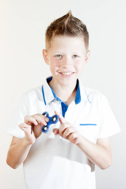 istock The boy twists the spinner in his hands 819670294