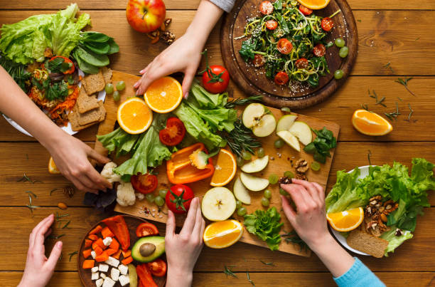 Dinner table, women eat healthy food at home kitchen Healthy food dinner table. Women at home together, eating fruits and vegetables, top view, flat lay, crop low carb diet photos stock pictures, royalty-free photos & images