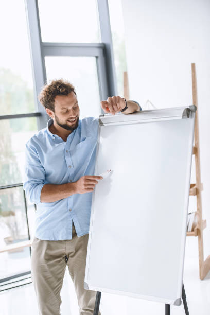 istock young businessman making presentation at white board in office 819671268