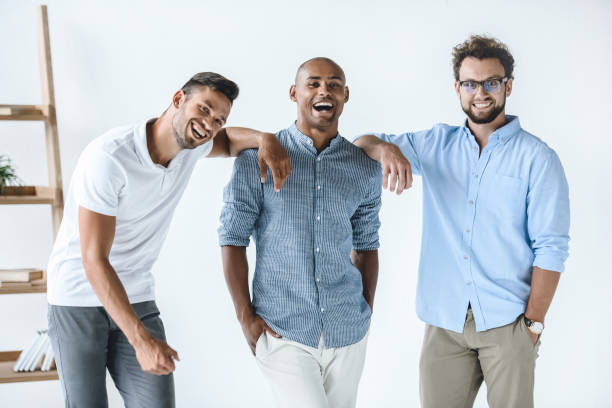 istock multiethnic group of young smiling businessmen standing in light office 819671328