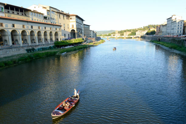 Firenze: people sailing with a boat on river Arno at Florence on Italy.