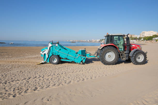 istock tractor with trailer cleaning beach in Benicassim 819676902