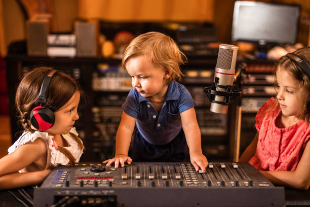 istock Three cute kids having a radio broadcast in a station. 819700292