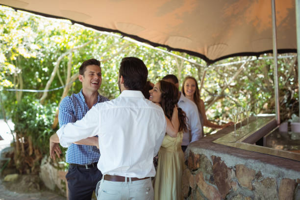 istock Smiling friends interacting while having a champagne at counter 819709320