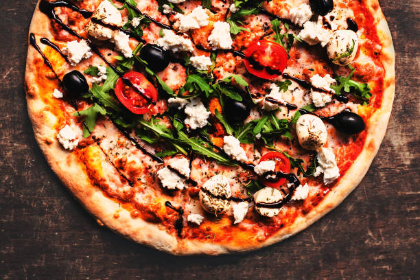 istock Fresh italian classic original pizza with cheese mozzarella,  pepperoni and salami on a rustic wooden table. 819716740