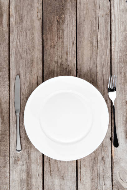 istock top view of arranged empty plate, fork and knife on wooden table 819720020