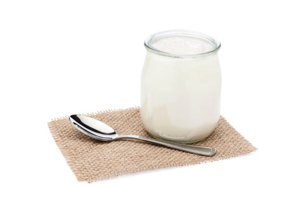 istock Yogurt in a glass container isolated on white background 819720168