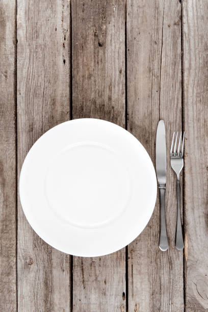istock top view of arranged empty plate, fork and knife on wooden table 819720240